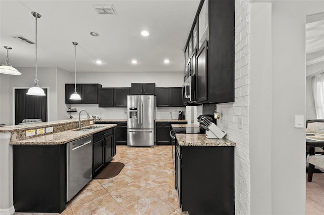 kitchen with an island with sink, hanging light fixtures, stainless steel appliances, dark cabinetry, and a sink