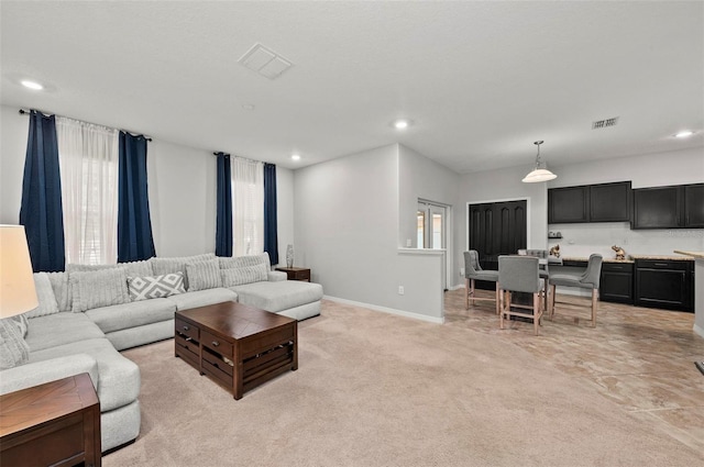 living room featuring light carpet, baseboards, visible vents, and recessed lighting