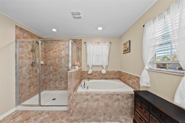 bathroom featuring a stall shower, a textured ceiling, and a bath