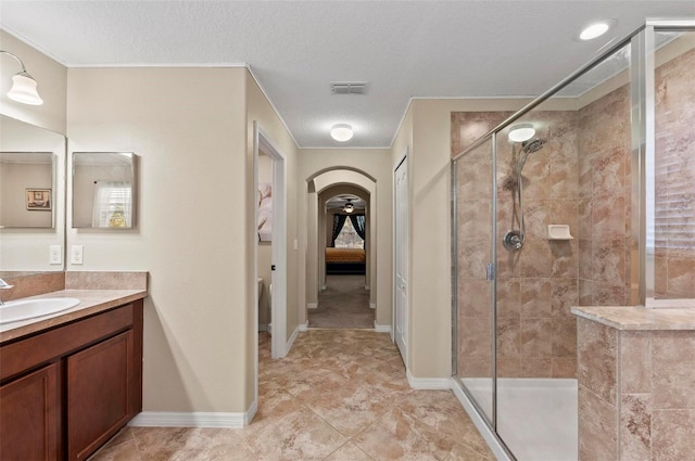 bathroom with vanity, a textured ceiling, and tiled shower