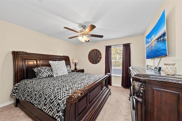 bedroom with ceiling fan, baseboards, and light colored carpet