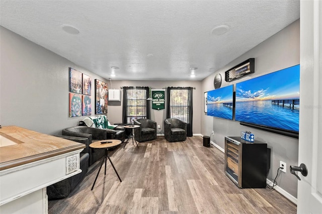 interior space featuring light wood-style floors, a textured ceiling, and baseboards