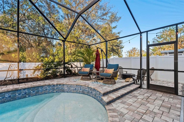 view of pool with a patio area, glass enclosure, and a fenced backyard