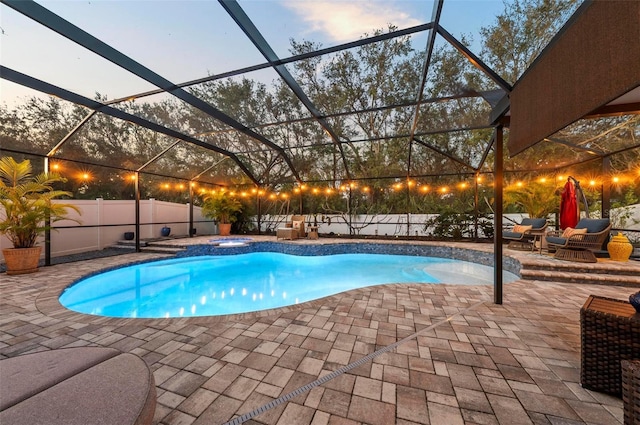 pool at dusk featuring a patio area, a lanai, and a fenced in pool