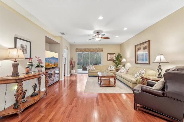 living room with ceiling fan and light hardwood / wood-style flooring