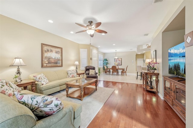 living room with wood-type flooring and ceiling fan