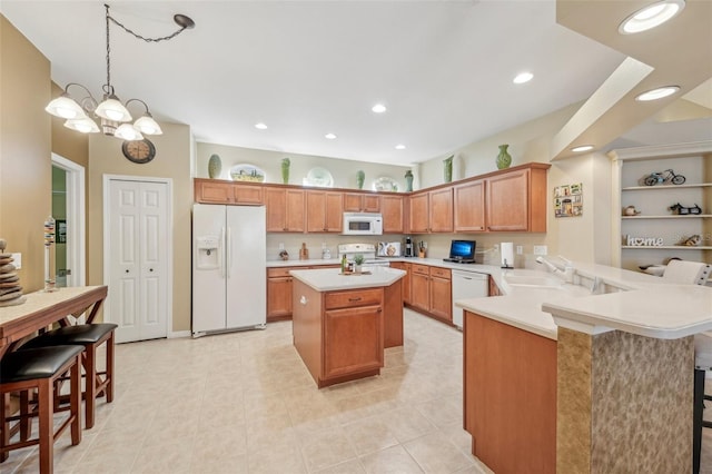 kitchen with pendant lighting, sink, white appliances, a breakfast bar, and kitchen peninsula