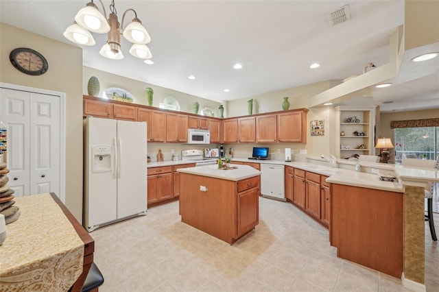 kitchen with decorative light fixtures, a kitchen bar, a center island, kitchen peninsula, and white appliances