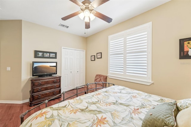 bedroom featuring wood-type flooring, ceiling fan, and a closet