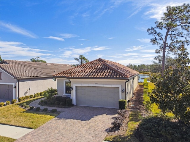 mediterranean / spanish-style home with a garage and a water view