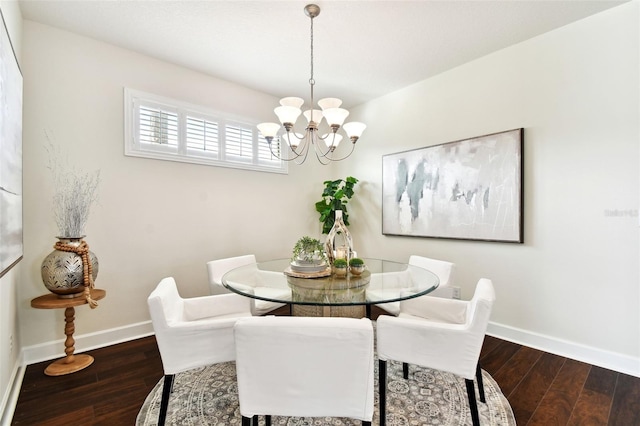 dining area featuring dark hardwood / wood-style flooring and a notable chandelier