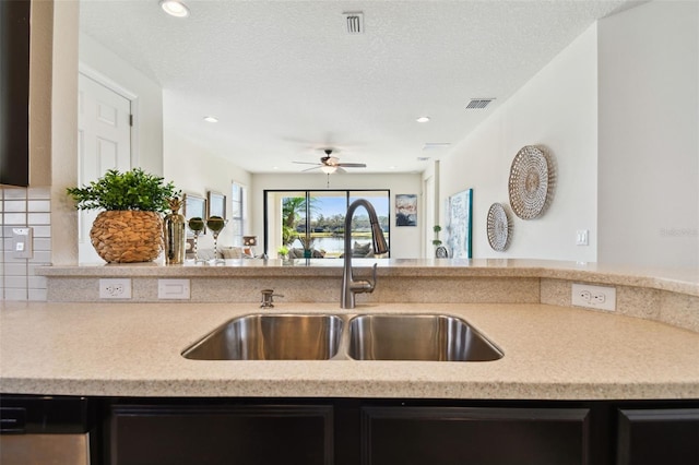 kitchen with sink, dishwasher, a textured ceiling, and ceiling fan