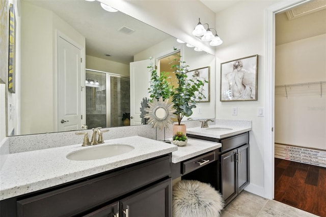 bathroom with a shower with door, hardwood / wood-style floors, and vanity