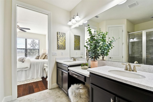 bathroom with a shower with shower door, ceiling fan, vanity, and tile patterned floors