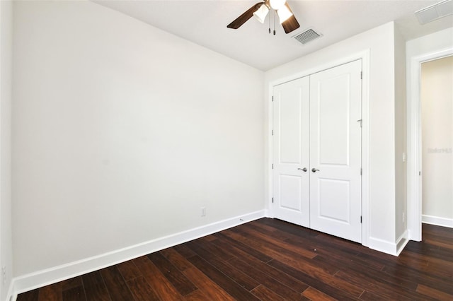 unfurnished bedroom with a closet, dark hardwood / wood-style floors, and ceiling fan