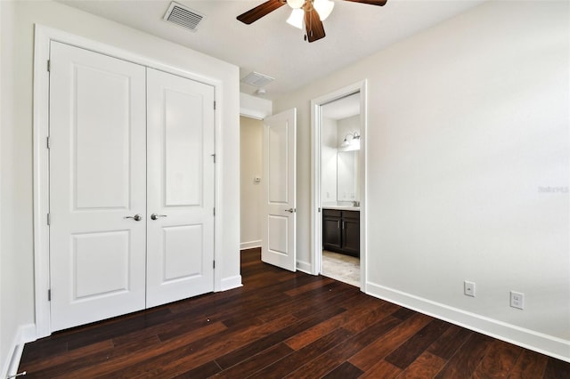 unfurnished bedroom with ceiling fan, dark hardwood / wood-style floors, ensuite bath, and a closet