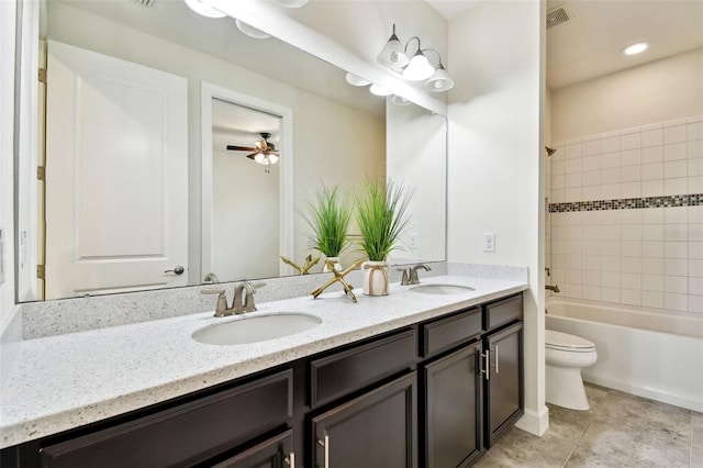 full bathroom featuring tiled shower / bath, vanity, toilet, and tile patterned floors