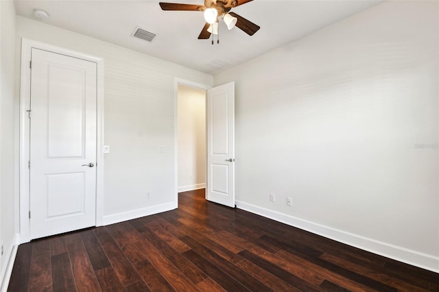 unfurnished bedroom with ceiling fan and dark wood-type flooring