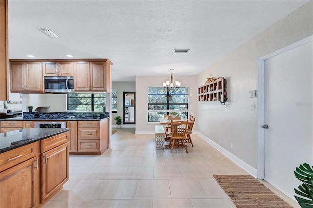 kitchen with tasteful backsplash, hanging light fixtures, a chandelier, and light tile patterned flooring