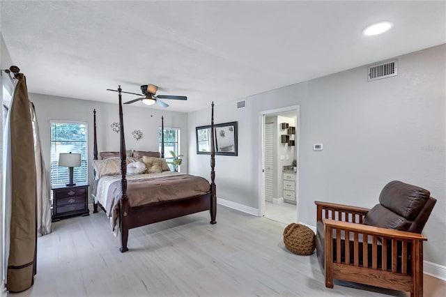 bedroom with multiple windows, ensuite bath, light hardwood / wood-style floors, and ceiling fan