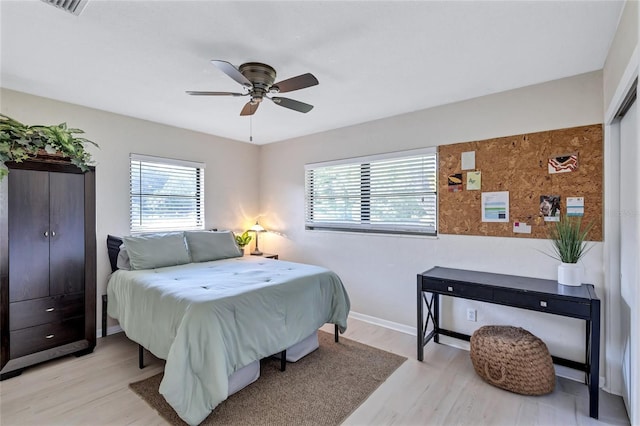 bedroom with multiple windows, ceiling fan, and light hardwood / wood-style flooring