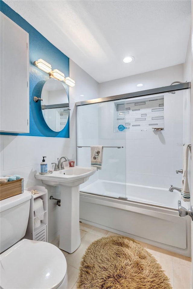 bathroom with enclosed tub / shower combo, tile patterned floors, and toilet