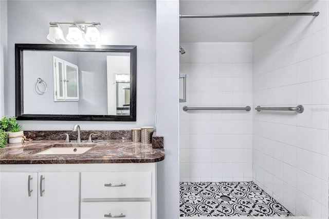 bathroom featuring tiled shower and vanity