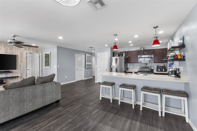1203 Desmond St, Port Charlotte, FL 33952 - kitchen featuring visible vents, stainless steel appliances, dark brown cabinets, light countertops, and a kitchen bar