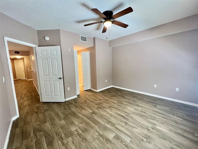 unfurnished bedroom with ceiling fan, hardwood / wood-style floors, and a textured ceiling