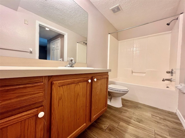 full bathroom featuring wood-type flooring, shower / bath combination, vanity, toilet, and a textured ceiling