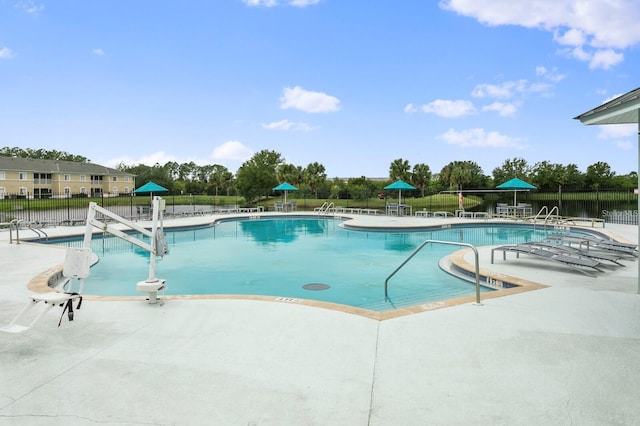 view of swimming pool with a water view and a patio area