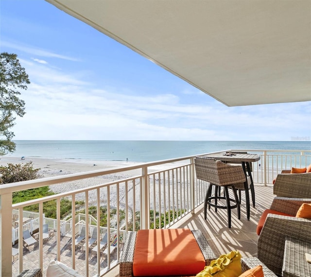 balcony featuring a beach view and a water view