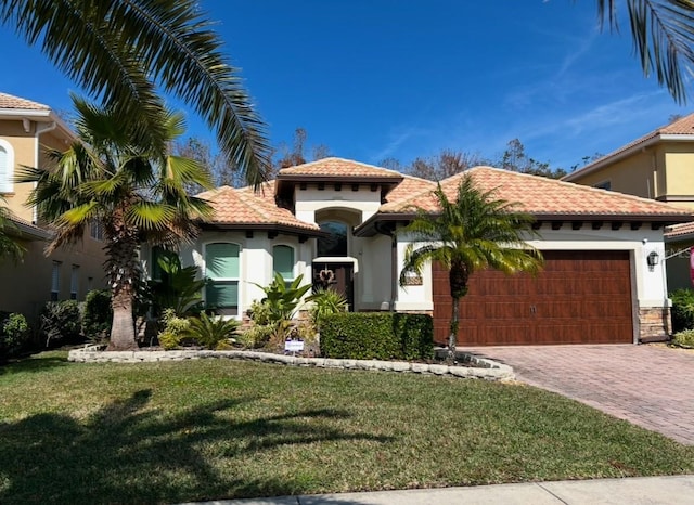 mediterranean / spanish-style home featuring a garage and a front yard