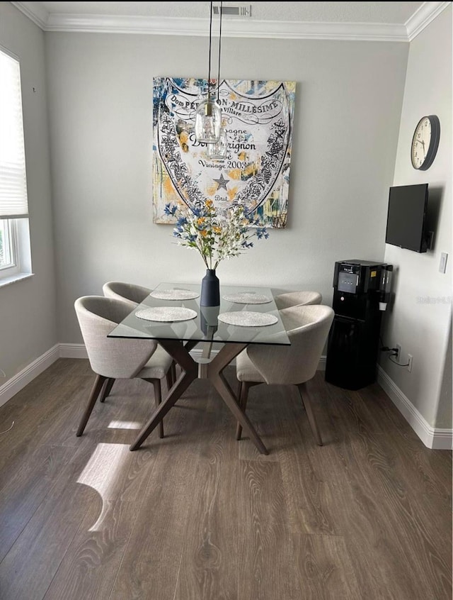 dining area featuring dark wood-type flooring and ornamental molding