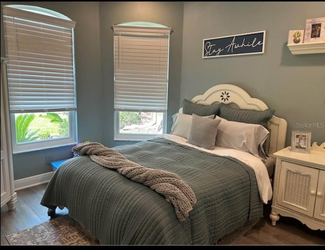 bedroom with dark hardwood / wood-style floors