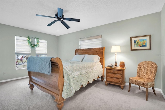 carpeted bedroom with ceiling fan and a textured ceiling