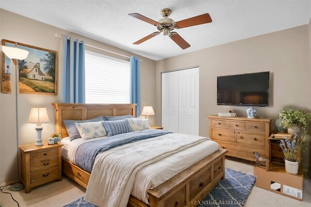 carpeted bedroom featuring ceiling fan and a closet