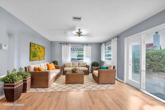 living room featuring light hardwood / wood-style flooring and ceiling fan