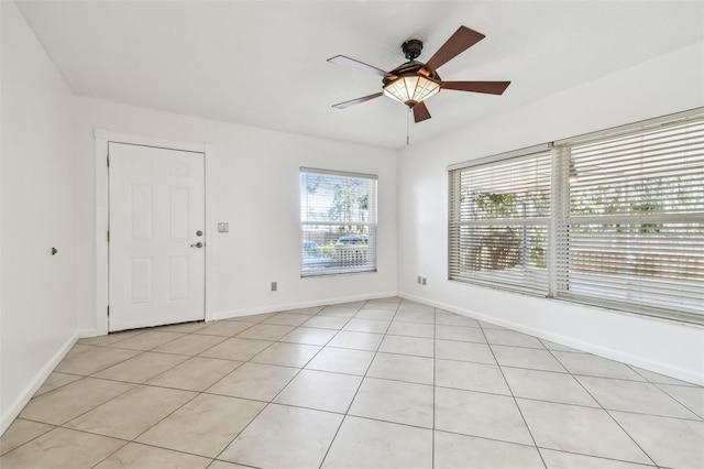 tiled spare room with ceiling fan