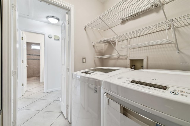 laundry room featuring washer and dryer and light tile patterned floors