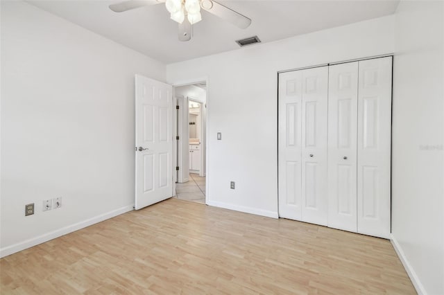 unfurnished bedroom with ceiling fan, light wood-type flooring, and a closet