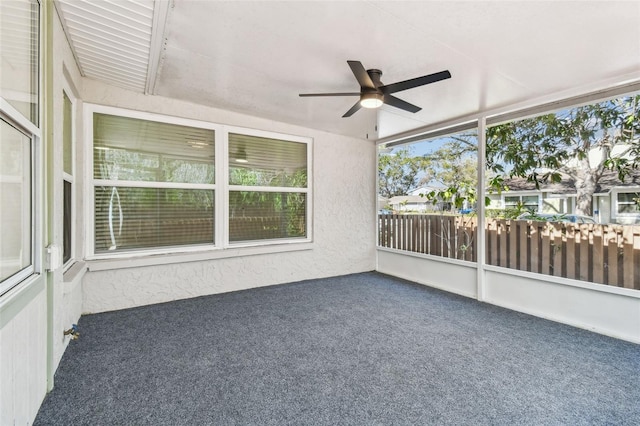 unfurnished sunroom with ceiling fan