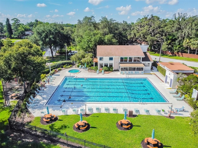 view of pool with a community hot tub, a patio, and a lawn