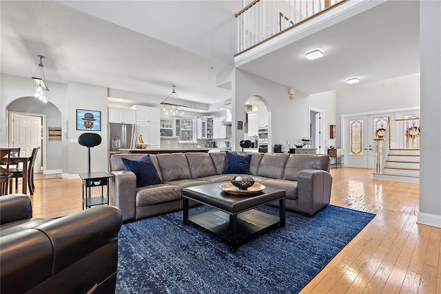 living room featuring a high ceiling and light hardwood / wood-style flooring