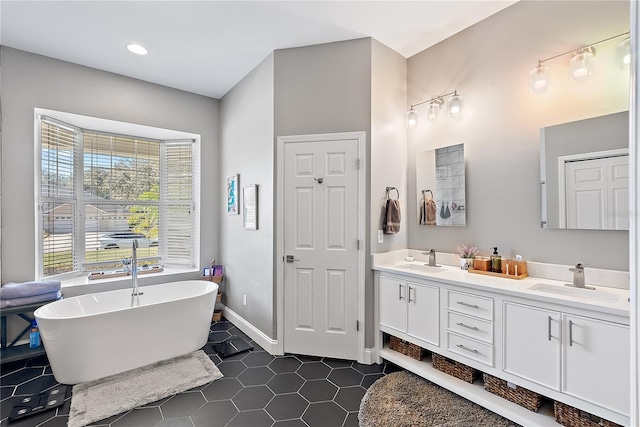 bathroom with tile patterned flooring, vanity, and a bath