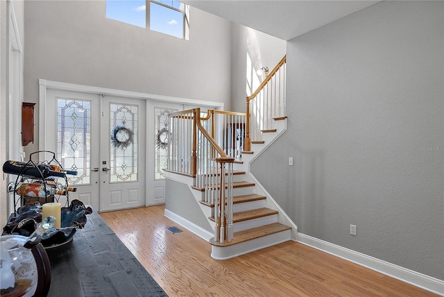 foyer with french doors and light hardwood / wood-style flooring