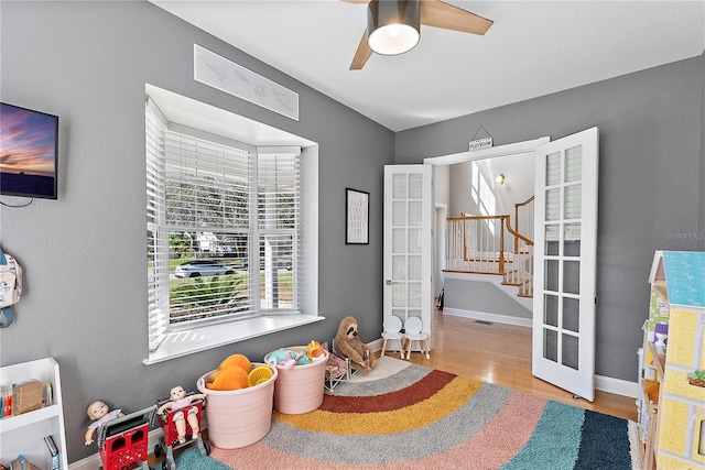 game room featuring light hardwood / wood-style flooring, ceiling fan, and french doors