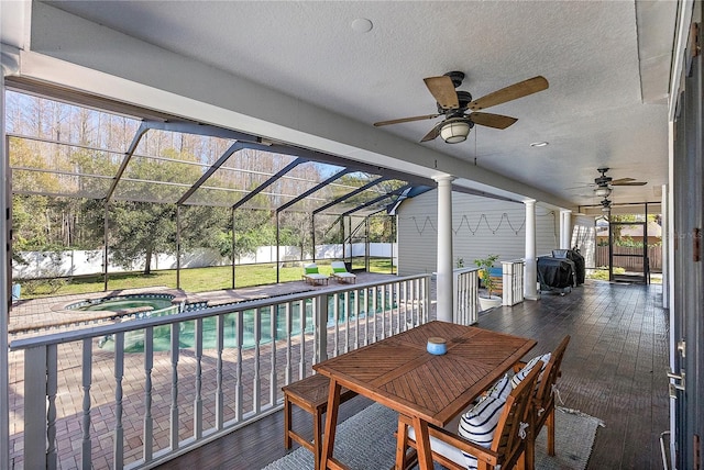 exterior space featuring ceiling fan, a swimming pool with hot tub, and glass enclosure