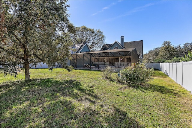 back of property featuring a yard and glass enclosure