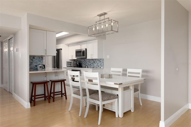 dining area with a chandelier and light hardwood / wood-style flooring